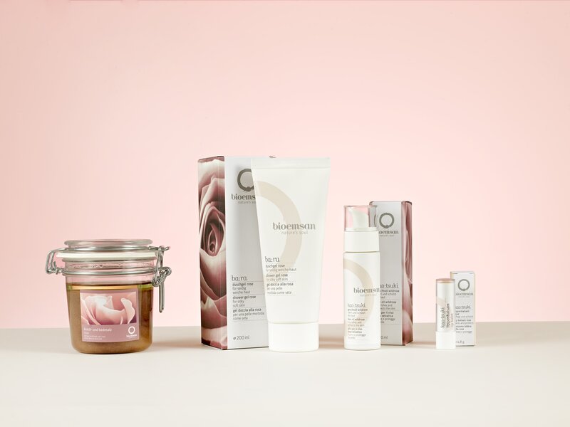 Rosa Kosmetikprodukte der Rosen-Pflegeserie auf hellem Hintergrund.   